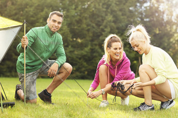 Group of friends putting up tent