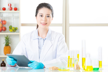 Asian female scientist touch the digital tablet holding soya bea