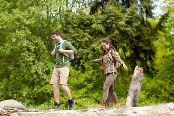 happy couple with backpacks hiking outdoors