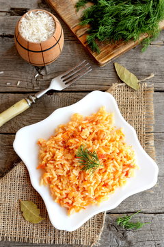 Risotto with vegetables on plate. Rice cooked with carrots, tomatoes, garlic and spices. Vegetarian and diet recipe. Top view