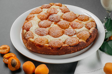 Homemade cheesecake with apricots on a gray background