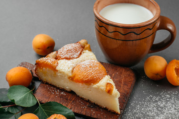 Homemade cheesecake with apricots on a gray background