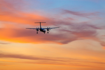 Fototapeta na wymiar Airplane landing in airport at sunset