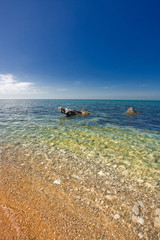 Fototapeta na wymiar sandy beach with stones in water
