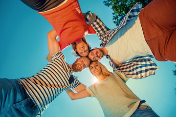 Happy group of friends hugging at the park