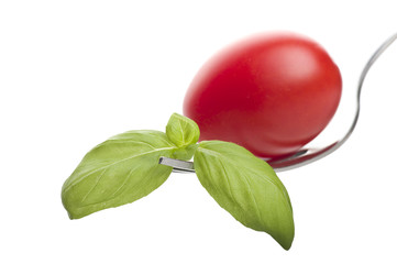 Iron fork with fresh tomato and basil