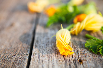 Zucchini flowers on a old wooden table close up, rustic style