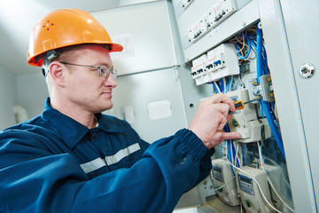 electrician with screwdriver repair switching electric actuator in fuse box