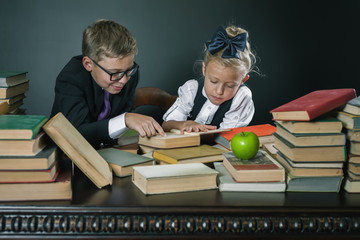 School kids reading a book at library