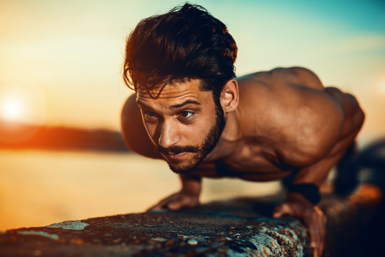 Young athletic man doing push ups outdoors