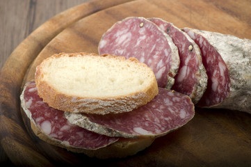 wooden cutting board with salami and bread