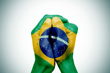 hands patterned with the flag of Brazil