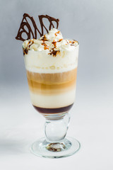 coffee with whipped cream,layers liqueur and milk in a transparent glass