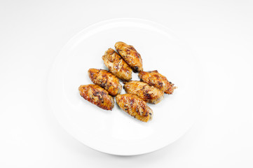 Grilled chicken wings in dish white on white background