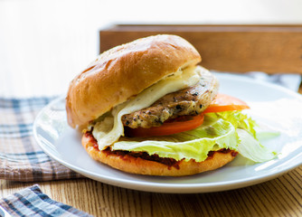 burger with grilled bun served on a wooden table