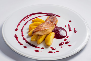 foie gras and baked potatoes with berry sauce on a white plate