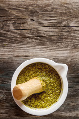 Homemade green pesto sauce with basil and pine nuts in white mor