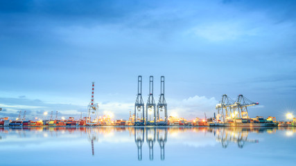 Obraz premium Logistics and transportation of International Container Cargo ship in a harbor with water reflections for logistic import export background and transport industry.