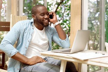 Positive smiling man talking on cell phone
