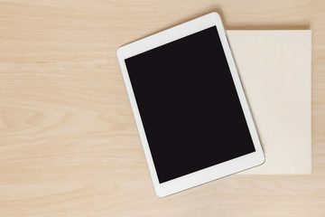 Tablet and the old book on wood