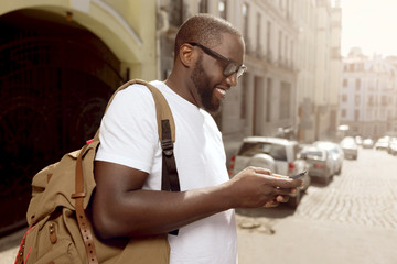 Pleasant smiling man using cellphone