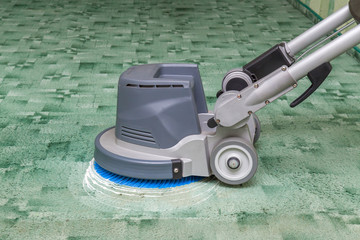Green carpets chemical cleaning with professionally disk machine. Early spring cleaning or regular...