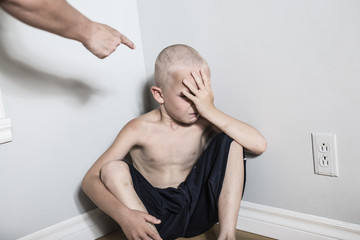 Neglected lonely child leaning at the wall