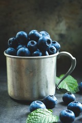 Blueberries still life on rustic metal cup, selective focus
