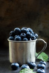 Blueberries still life on rustic metal cup, selective focus