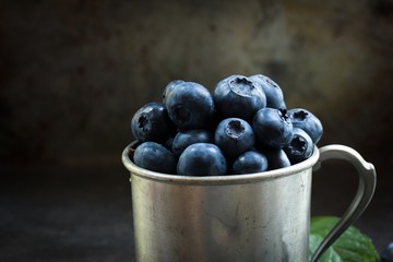 Blueberries still life on rustic metal cup, selective focus