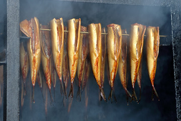 Golden smoked fish in a smoker - 117193427