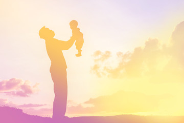 Father took the baby learn to walk at sunset.