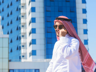 Outdoors portrait of a handsome arabian man talking on a cell phone
