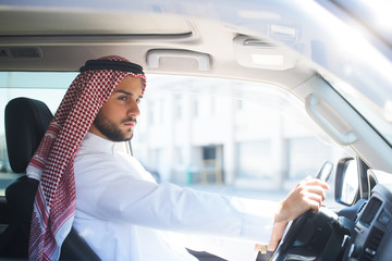 Portrait of a handsome arabian man driving a car