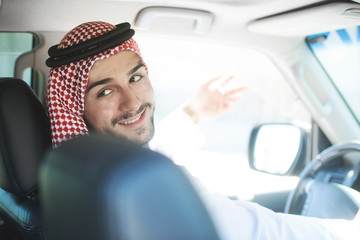 Portrait of a handsome arabian man driving a car