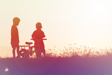 Fototapeta na wymiar two little boys bike silhouette