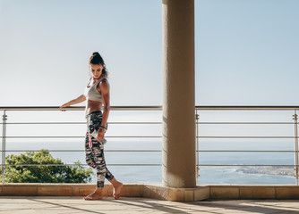 Beautiful woman with muscular body standing in the balcony