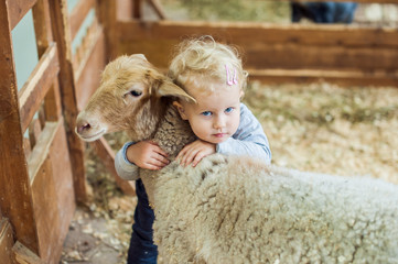 Girl hugging lamb © galitskaya