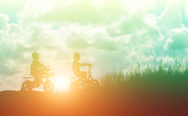 Obraz na płótnie Canvas two little boys bike silhouette