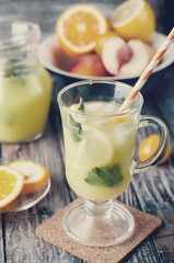 Refreshing lemonade drink and ripe fruits. Toned photo