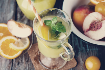 Refreshing lemonade drink and ripe fruits. Toned photo
