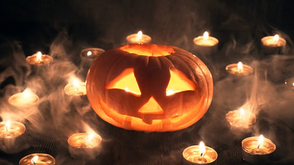Carved Halloween pumpkin on a black background with room for images.