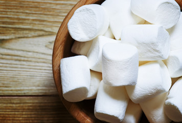 Large marshmallow in bowl, wooden background, top view