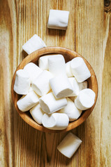 Large marshmallow in bowl, wooden background, top view