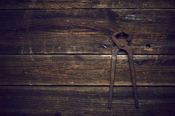 old rusty tongs on wooden boards background