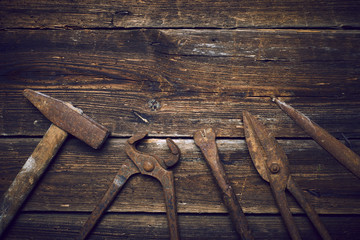 Grungy old rusted tools on a wooden background (processing cross-process)