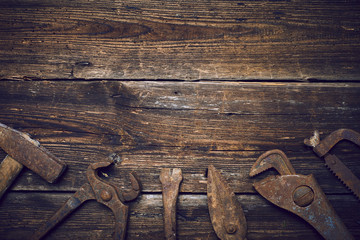 Grungy old rusted tools on a wooden background (processing cross-process)