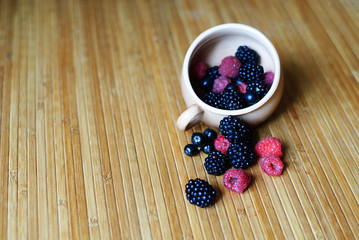 Fototapeta na wymiar Blackberries, raspberries and currant in the cup