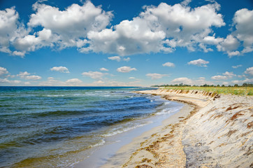 Sea waves washed clean beach made of shells. Landscape on a wild beach. The sea in the summer.