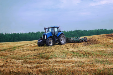 agricultural tractor working on the field in Belarus, Minsk, harvesting